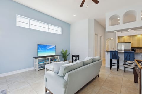 Open Living Room with Sofa, TV, and Kitchen Bar