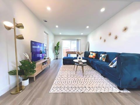 Sleek living room with comfortable seating, large TV, and a foosball table for entertainment.