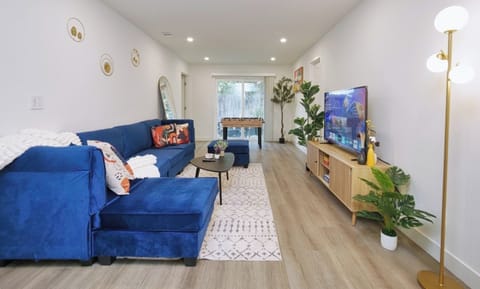 Sleek living room with comfortable seating, large TV, and a foosball table for entertainment. (1)