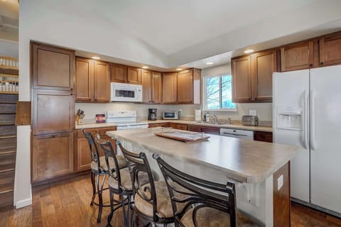 Bright and welcoming kitchen with modern appliances, a spacious island, and seating for everyone—perfect for cooking and gathering!