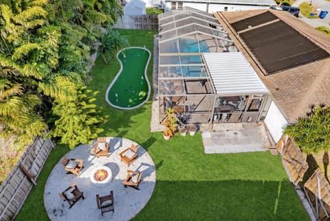 From above, see the ultimate backyard paradise—private pool, lush greenery, and a fun-filled putt-putt course await!