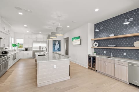 Your spacious gourmet kitchen features gleaming quartz countertops, premium appliances, and a stunning geometric accent wall perfect for culinary adventures.