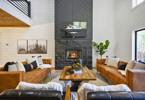 The warm and cozy living room invites you to relax with plush seating, a tall fireplace, and thoughtful touches for a perfect gathering spot.