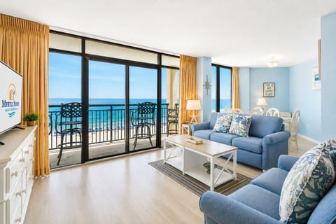 Panoramic direct ocean views fill the living room, which flows seamlessly into the dining area and kitchen, creating a gorgeous open-concept floor plan.