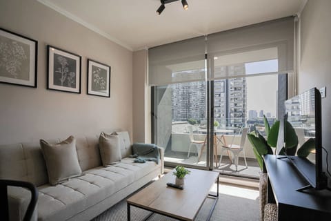 Relax in the stylish living room with a cozy sofa and enjoy city views from the charming balcony.