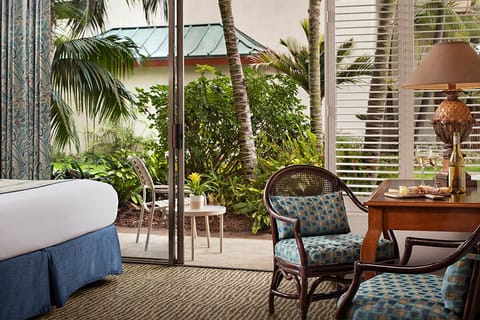 Sip morning coffee beside tropical greenery just outside.