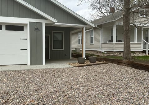 Both houses next to one another. The new build is the gray. The house with the white porch is the older home.