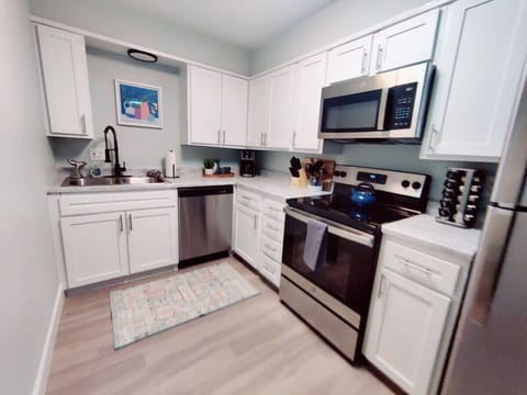 Transform your cooking experience with this stunning kitchen adorned with sleek stainless steel appliances and elegant white cabinets.