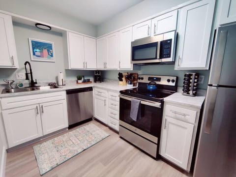 Transform your cooking experience with this stunning kitchen adorned with sleek stainless steel appliances and elegant white cabinets.