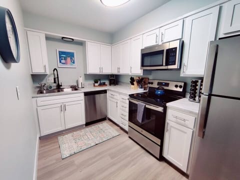 Transform your cooking experience with this stunning kitchen adorned with sleek stainless steel appliances and elegant white cabinets.