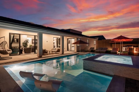 Escape to this luxurious Chic Oasis haven, where a shimmering pool and vibrant sunset skies create the perfect backdrop for your evening relaxation.