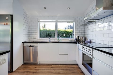 The kitchen has a dishwasher, fridge/freezer, cooktop, and oven.