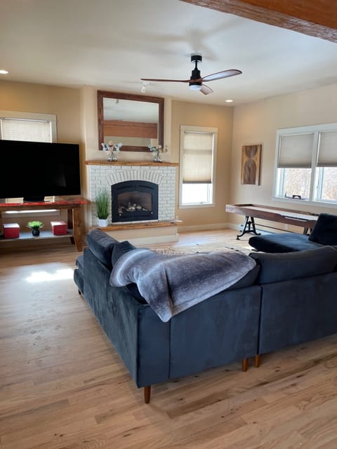Main living room with huge sectional, amazing shuffleboard table and large TV
