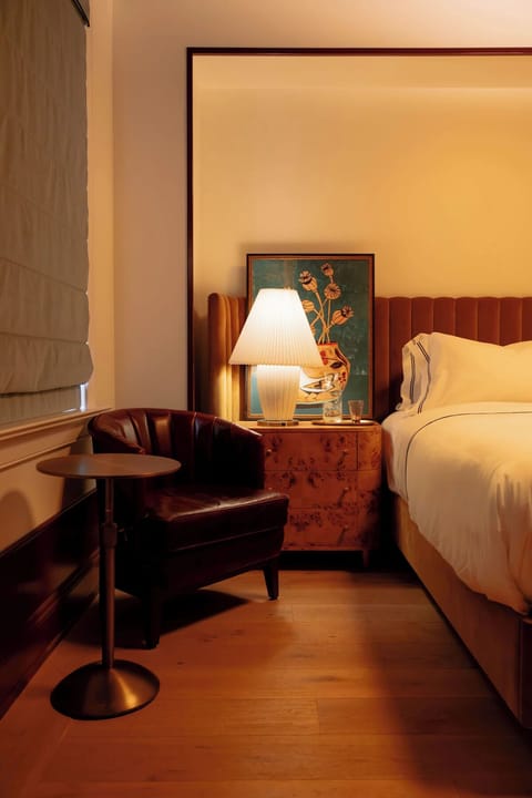 Unwind in a warmly lit bedroom with cozy reading nook.