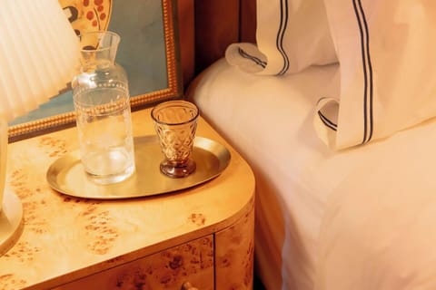 Sip something refreshing beside crisp linens and warm glow.