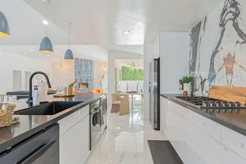 Sleek galley kitchen w/ modern finishes, dual prep spaces, and an open flow into the dining and living areas.