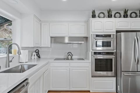 Bright full kitchen with counter stools