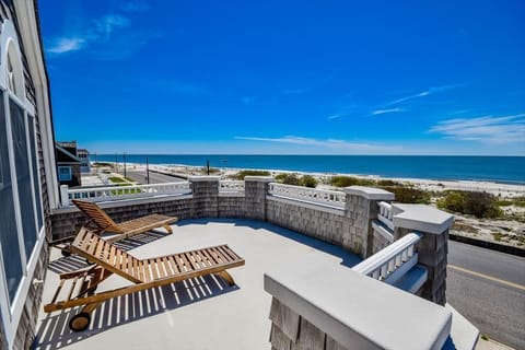 Expansive oceanfront balcony with lounge seating, offering uninterrupted panoramic views of the coastline.