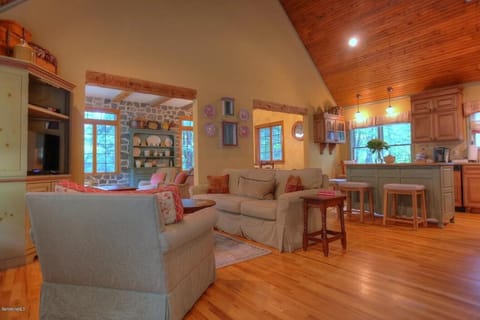 Living area with cathedral ceilings and adjacent kitchen