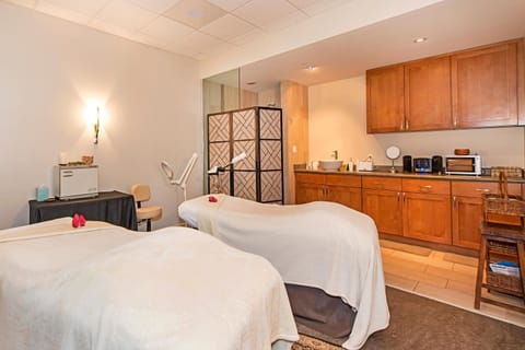 Indulge in a rejuvenating couple's massage in this private treatment room at Honua Kai's spa, the perfect retreat for relaxation and pampering.