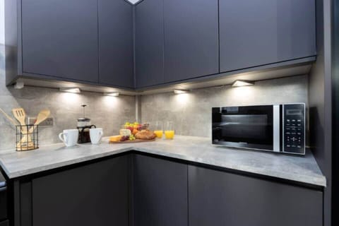 Enjoy a sleek, modern kitchen with ample counter space, under-cabinet lighting, and essential appliances—perfect for easy meal prep.