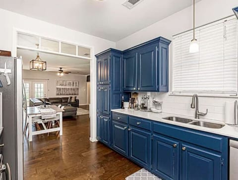 Kitchen: Vibrant blue cabinets and sleek appliances invite culinary creativity!