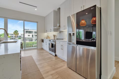 Kitchen | High-end appliances, fully stocked with cooking essentials + a balcony with views of the private dock.