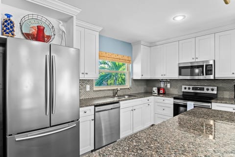 Sand Castle Kitchen Island in foreground with ample counter space and showing major appliances.
