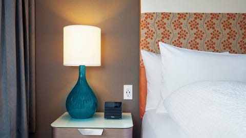 Unwind under warm bedside lighting with crisp, inviting linens.