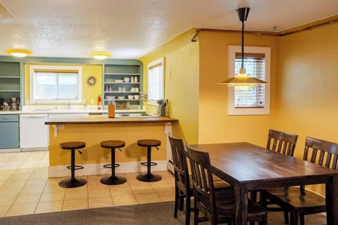 The bright and thoughtfully stocked kitchen features roomy bar seating adjacent to an open-concept dining and living room, ideal for gathering. 