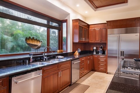 Gourmet kitchen with island seating, wine fridge, and high-end appliances—cook, gather, and enjoy together.