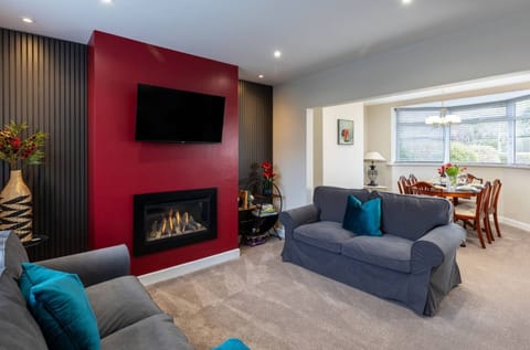 Large sitting area with real flame fire and adjoining dining room