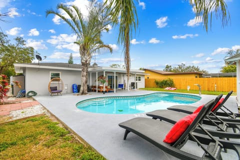 Luxury Largo pool home near Indian rocks Beach with heated swimming pool, premium outdoor loungers, and private fence yard. Modern Florida vacation rental featuring tropical landscaping and contemporary outdoor furnishings, perfect for family getaway