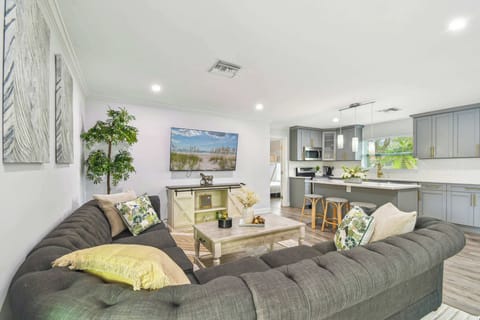 Spacious open-concept living area in Largo luxury rental with designer kitchen, comfortable seating, and coastal-inspired décor. Perfect blend of modern amenities and Florida style. 