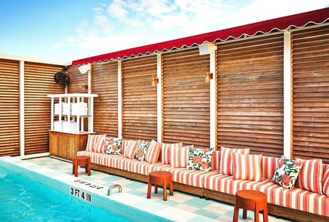 Lounge poolside on striped cushions in a chic, private setting.