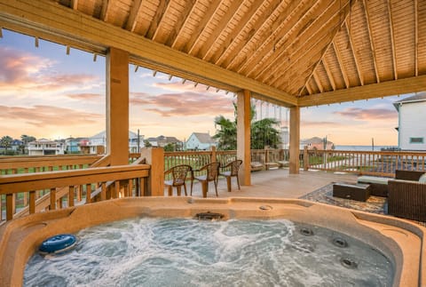 Beachfront hot tub retreat with covered outdoor lounge, bar seating, and panoramic Bolivar Peninsula sunset views at Townsend Drive near Crystal Beach.
