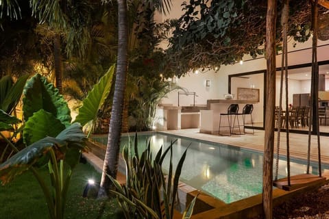 Beautiful outdoor bar for enjoyment, well-lit next to the pool.
