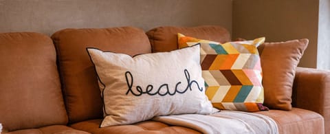 Cozy corner sofa with textured cushions and a welcoming beach vibe.