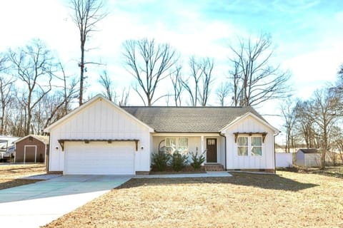 one story new farm house with covered front porch and fully fenced backyard