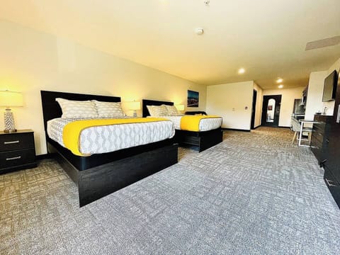 Cozy bedroom featuring a comfortable beds and a sofa with vibrant throw pillows, ideal for relaxing after a day of exploring.