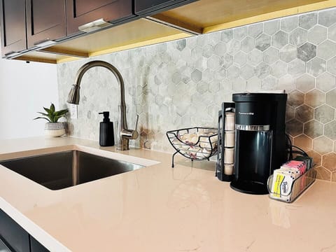 A chic coffee station with a variety of supplies, set against a beautiful hexagonal backsplash for a stylish start to your day.