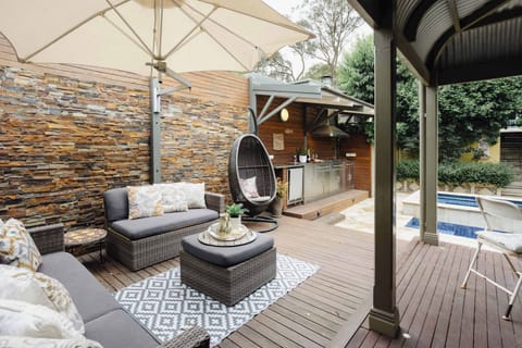 Relaxing deck area with comfortable sofa chairs, offering a perfect spot to unwind while being just steps away from the refreshing pool.