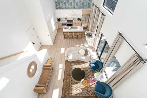 Soaring ceilings and designer touches define this open-concept living room, complete with a smart TV elegant lounge seating for ultimate relaxation.