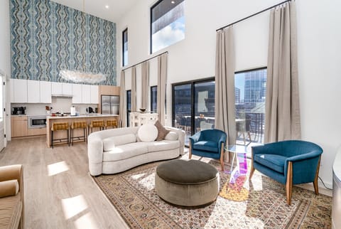 Soaring ceilings and designer touches define this open-concept living room, complete with a smart TV elegant lounge seating for ultimate relaxation.