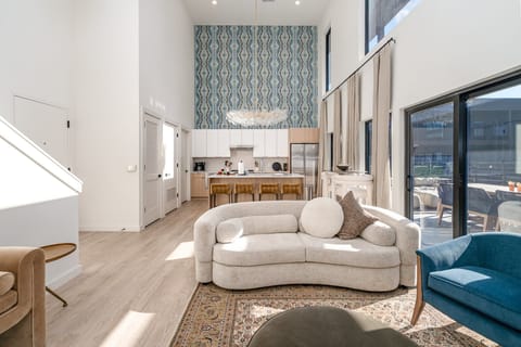 Soaring ceilings and designer touches define this open-concept living room, complete with a smart TV elegant lounge seating for ultimate relaxation.