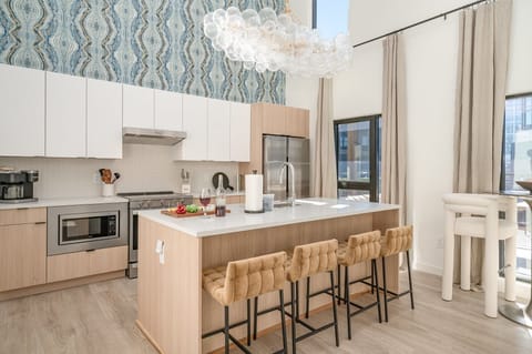 Sleek and modern, this kitchen shines with stainless steel appliances and a spacious island with bar seating for four.