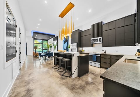 This open-concept kitchen and dining area blends sleek design with a spacious layout, ideal for hosting or family meals.
