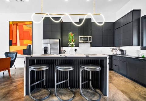 Striking gold pendant lights and clean, modern lines give this kitchen a luxurious edge, while the open layout makes it perfect for hosting or cooking up your favorite meals.