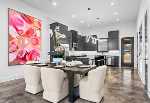 The dining area stands out with its bold artwork and clean, contemporary lines, offering a stylish and lively space for hosting family and friends.