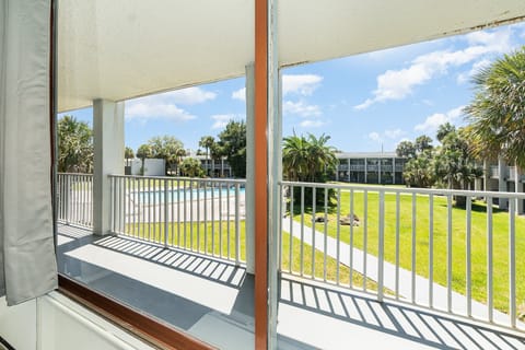Relax on the balcony and enjoy stunning views of the lush greenery and sparkling pool below.